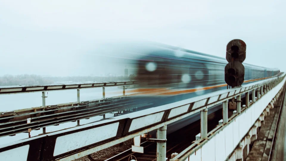 Motion blur of a train speeding across a bridge in Kyiv, Ukraine, showcasing transport dynamics.