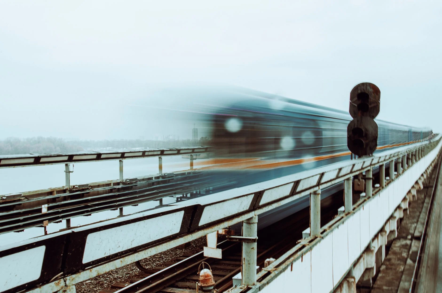 Motion blur of a train speeding across a bridge in Kyiv, Ukraine, showcasing transport dynamics.