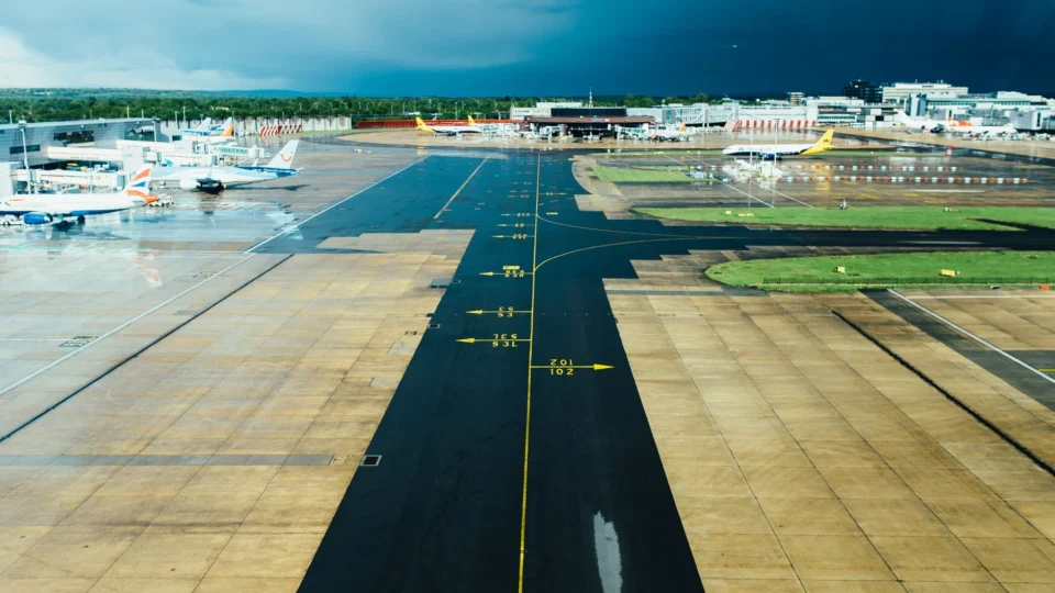 Aerial view of an airport runway with several parked planes on a cloudy day. Ideal for travel and aviation themes.