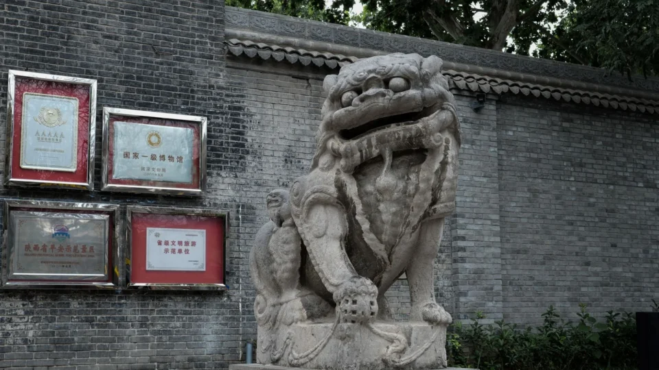A detailed view of a traditional Chinese stone lion statue in Xi'an, Shaanxi Province.