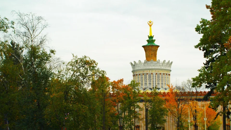 View of Pavilion Ukraine at the All-Russian Exhibition Center with autumn trees and people walking