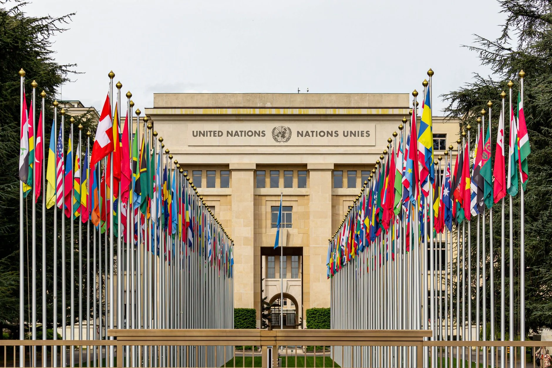 View of the United Nations Office in Geneva adorned with flags of various countries.