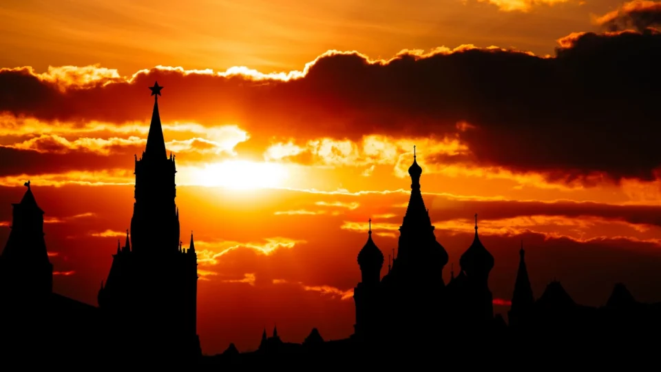 Dramatic silhouette of Moscow Kremlin towers against a vibrant sunset sky.