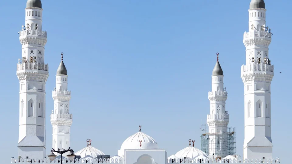 Bright daytime view of the historic Quba Mosque with its iconic minarets in Madinah, Saudi Arabia.