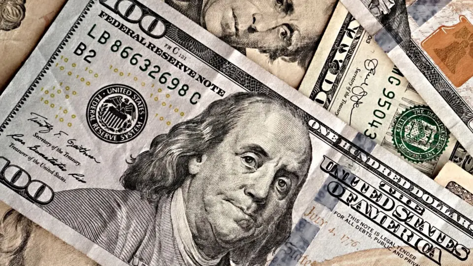 Detailed image of US dollar bills featuring various denominations and historical figures.