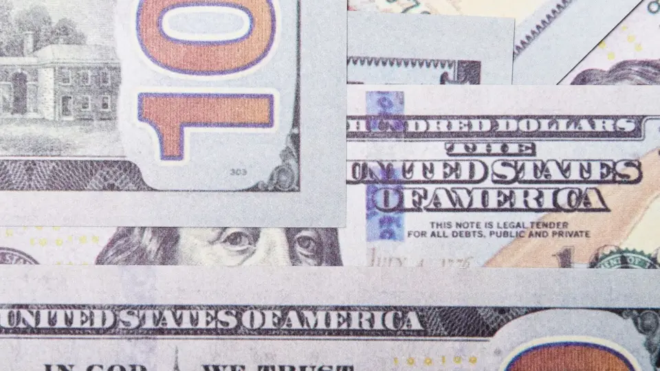 Detailed close-up of layered US dollar banknotes focusing on geometric patterns and financial concept.