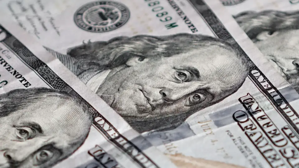 Detailed image of US hundred-dollar bills featuring Benjamin Franklin.