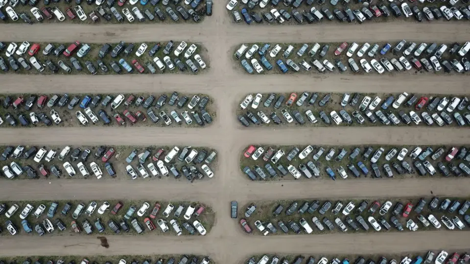 High angle view of numerous vehicles in an organized car lot, showcasing variety and structure.